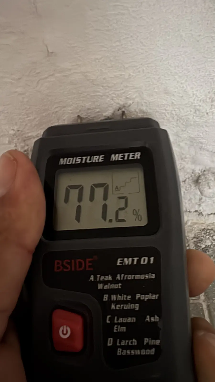 Medidor de humedad marcando 77,2 % sobre una pared afectada por una filtración