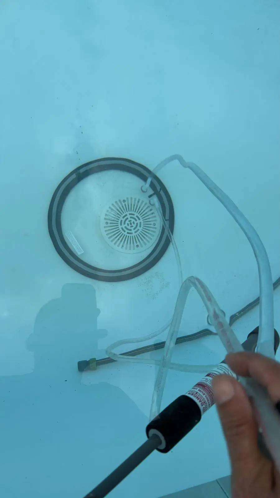Jeringa de tinte aplicada bajo el agua junto al sumidero de una piscina
